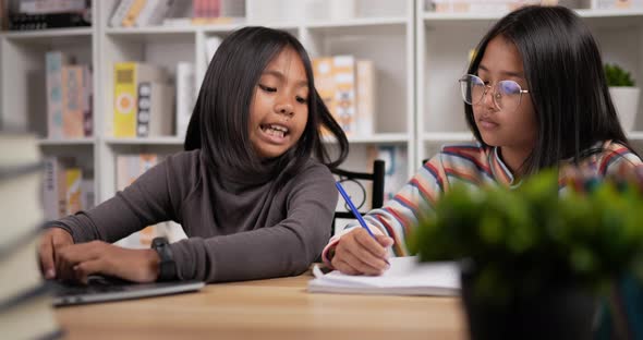 Two girls saving money with pink piggy bank alt