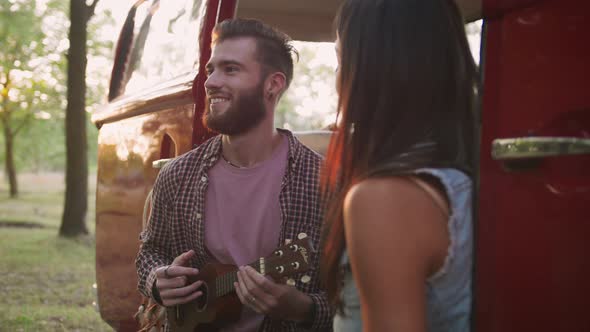 Happy Young Mixed Race Couple Playing Instruments and Having Some Fun in Retro Hippie Minibus in alt
