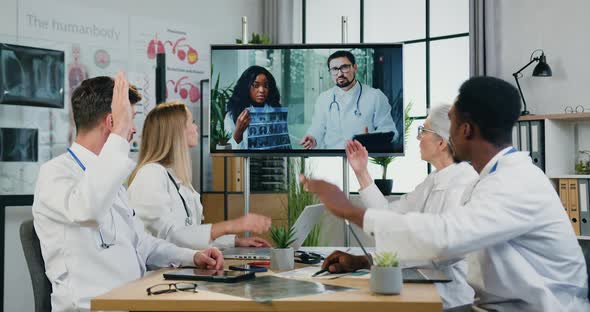 Male and Female Doctors Voting During Online Consultation in Modern Clinic Office alt