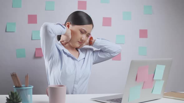 Asian woman working on a laptop was sick with body pain sitting