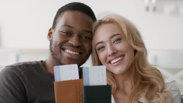 Happy Multiethnic Couple Showing Travel Tickets And Passports Posing Indoors alt