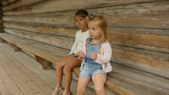 Children Sit On The Wooden Bench. Kids On The Village. 