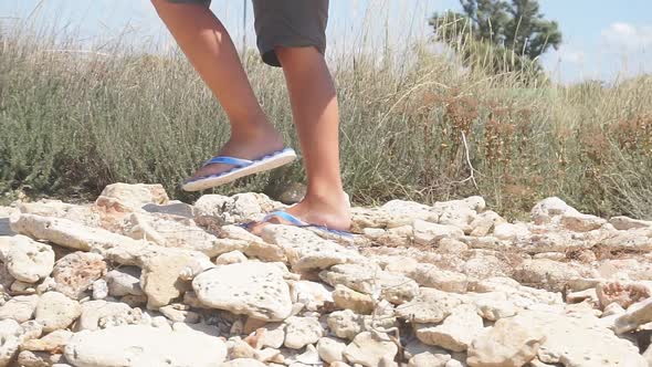 Closeup of Men's Feet Dressed in Slates Walking on Rocks Slowmotion Video on a Sunny Day