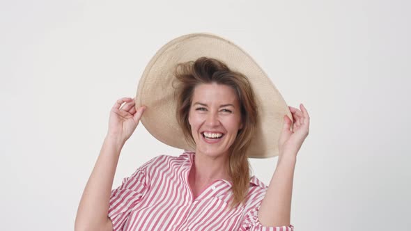 Woman Catching Hat and Smiling