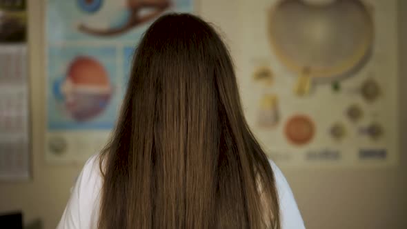 Smiling Eye Doctor Optometrist Turns Around and Looks at You Holding Ophthalmoscope alt