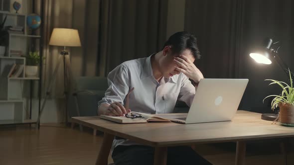 Tired Asia Businessman While Working From Home At Living Room At Night alt