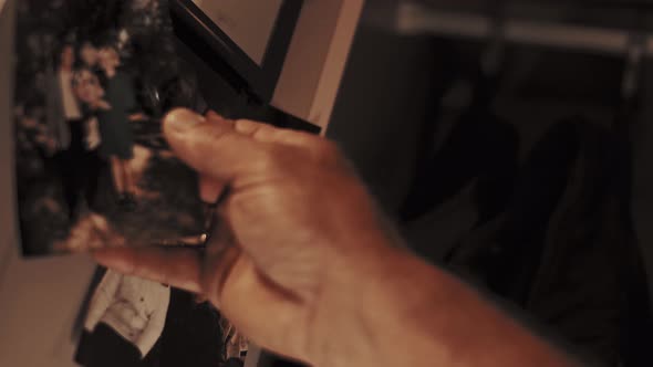 Production worker pulls a family photo out of his locker in the locker room. Close-up