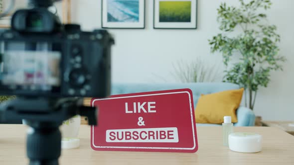Video Camera Recording Table with Eco Cosmetics and Like and Subscribe Sign on Table alt