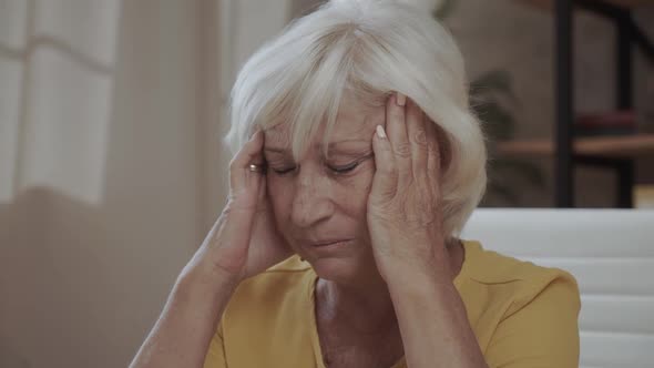 Health Care Pain Stress Age and People Concept  Face of Senior Woman Suffering From Headache alt