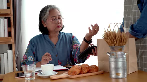 Elderly Asian Woman Using a Smart Watch Mobile Payment alt