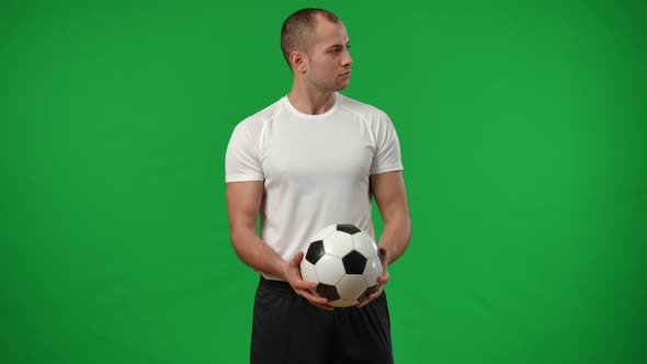 Confident Caucasian Young Man Catching Football Ball in Slow Motion on Green Screen Looking at alt