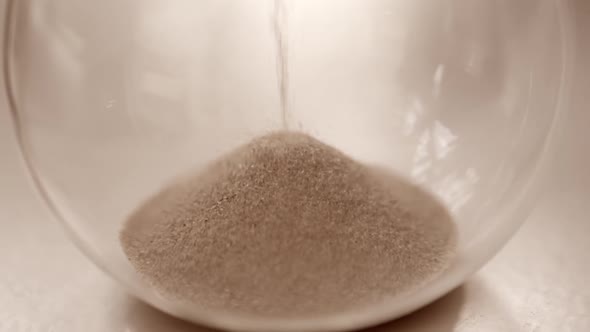 Hourglass sand falling in slow motion close up alt
