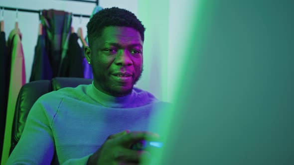 Happy Afroamerican Man Playing Computer Game Using Gamepad  Medium Shot alt