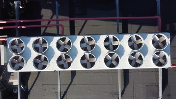 Industrial AC system with 14 fans on rooftop at sunny day - Top-down ascending aerial from closeup t alt