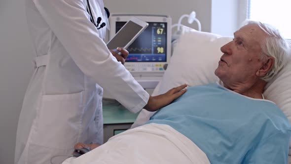 Senior Man Speaking with Nurse alt
