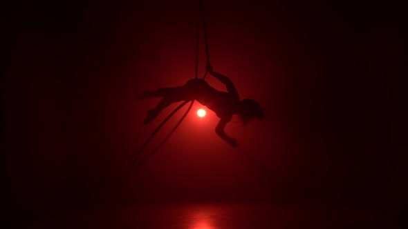 Aerial Acrobat in the Ring. A Young Girl Performs the Acrobatic Elements in the Air Ring on Red alt