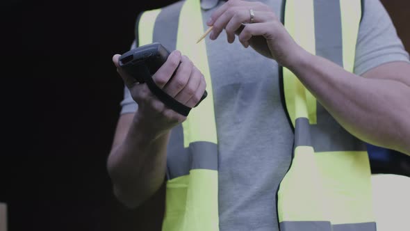 Delivery man scanning boxes with barcode scanner