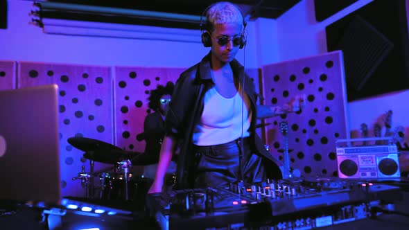 Young happy people playing music with dj mixer and drum in house studio alt