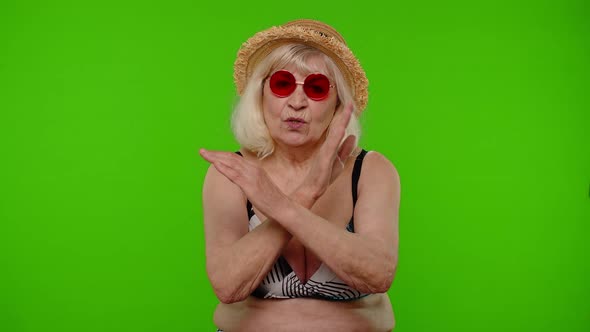 Mature Woman Traveler in Red Sunglasses Showing Stop Sign Dislike Gesture Bad Idea Wrong Choice alt