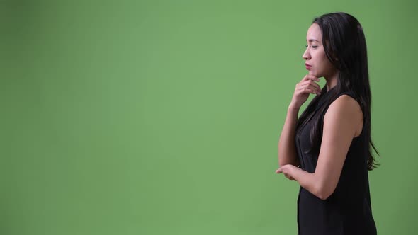 Profile View of Young Beautiful Asian Businesswoman Thinking alt