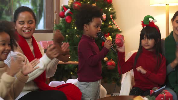 Diverse group of children and mothers singing celebrating Christmas together at home