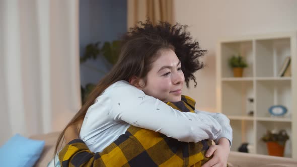 Smiling Multiracial Young Couple Hugging Relaxing on Couch at Home alt