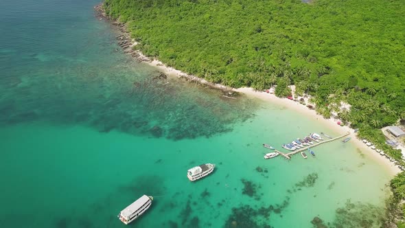 Scenic Aerial View of a Green Lagoon with Boats Floating on the Pristine Water. alt