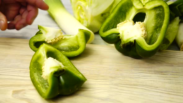 A cutting a green bell pepper into pieces, cooking vegetables