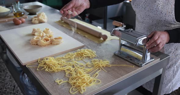 Woman working inside pasta factory while doing fresh italian tagliolini alt