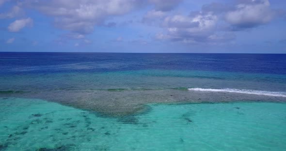 Natural flying clean view of a white paradise beach and aqua blue water background in 4K alt