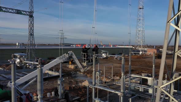 Men Are Working at the Construction Site, Standing on the Crane,  alt