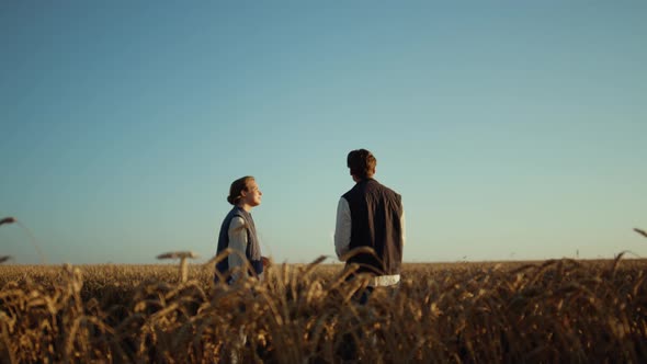Agricultural Partners Discussing Harvesting Season at Golden Sunset Wheat Field alt