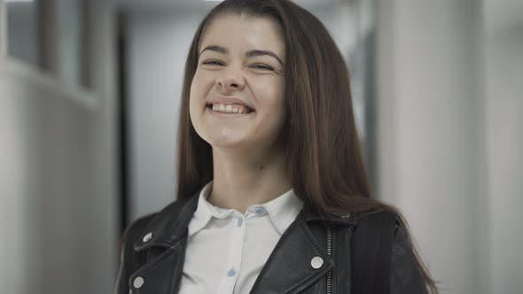 Closeup Portrait of Shy Teenage Brunette Girl Winking and Smiling at Camera alt
