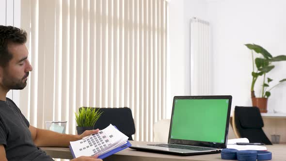 Man in the Living Room Looking at Green Mockup Screen on the Computer alt