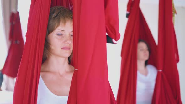 Pretty Lady Sits in Red Hammock and Practices Meditation alt
