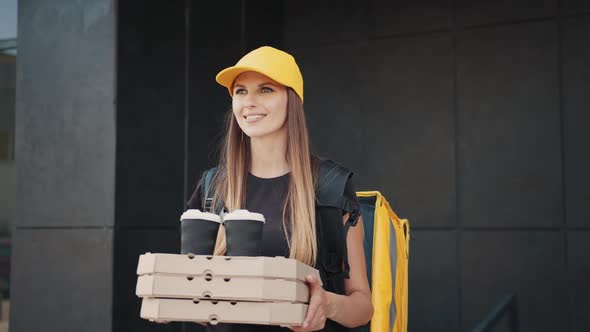 Woman Giving a Fast Food Order on the Background of a Modern Building Near the alt