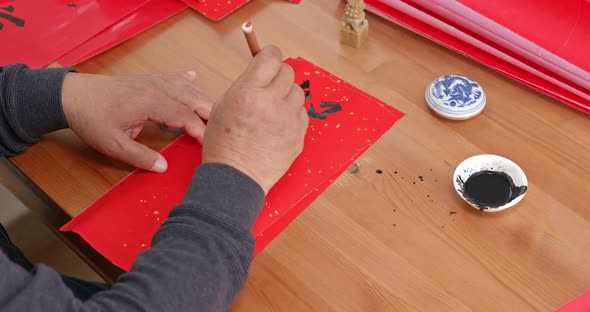 Man write chinese calligraphy for lunar new year alt