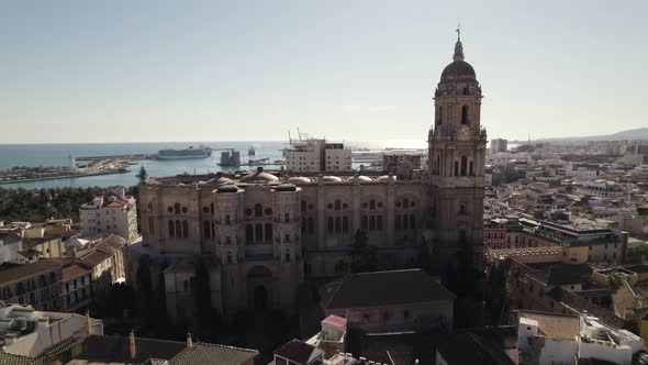 Malaga Cathedral with port in background, Spain. Aerial backward
