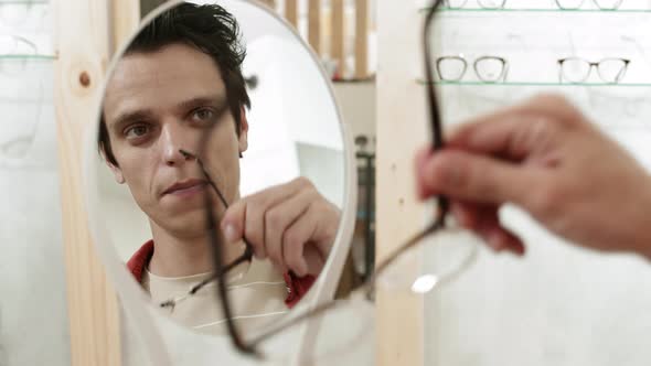Male Customer Choosing Eyeglasses in Shop alt