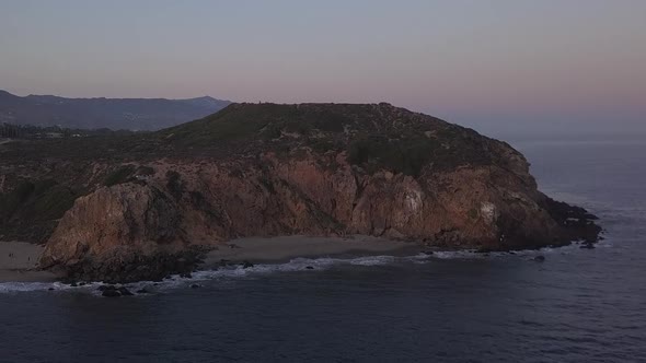 AERIAL: Flight Over Malibu, California View of Beach Shore Line Pacific Ocean at Sunset with alt