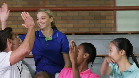 Volleyball coach giving high five to female players 4k alt
