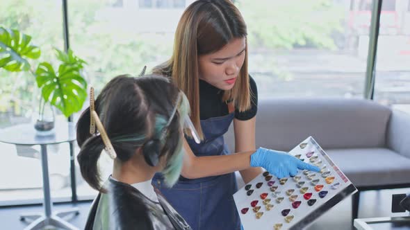 Asian professional female hairstylist giving an advise for best hairdo, haircut and color hair. alt