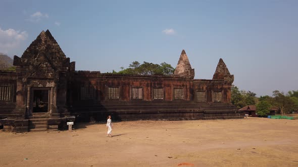 Woman walking near ancient Khmer palace, Wat Phou ruined Hindu Temple complex Architecture Laos Asia