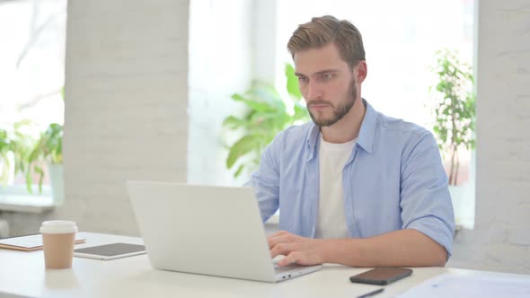 Young Creative Man Working on Laptop in Modern Office alt