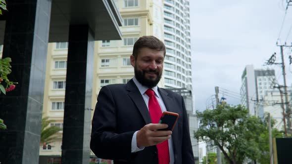 A Business Man Texting Phone in the Street alt