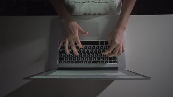 Woman sits at a laptop, works and writes letter on keyboard to her boss, Freelancer life, Work late