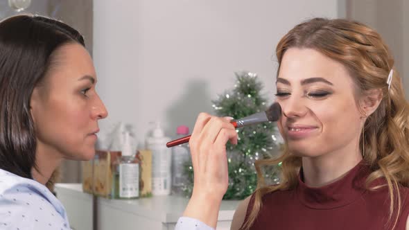 Fixing Makeup. Treatment of the Face with a Brush with Applied Powder alt