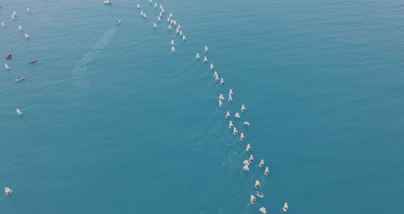 Small Training Sailing Yachts with Athletes in the Regatta. Training Sailing Yachts Float on the Sea