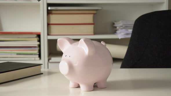 Man Introducing Fifty Euros in Piggy Bank
