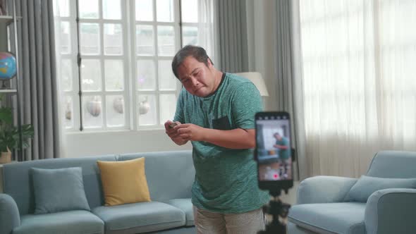Asian Man Blogger Shoots Video Content For Social Networks By Smartphone Camera, Magician With Cards alt